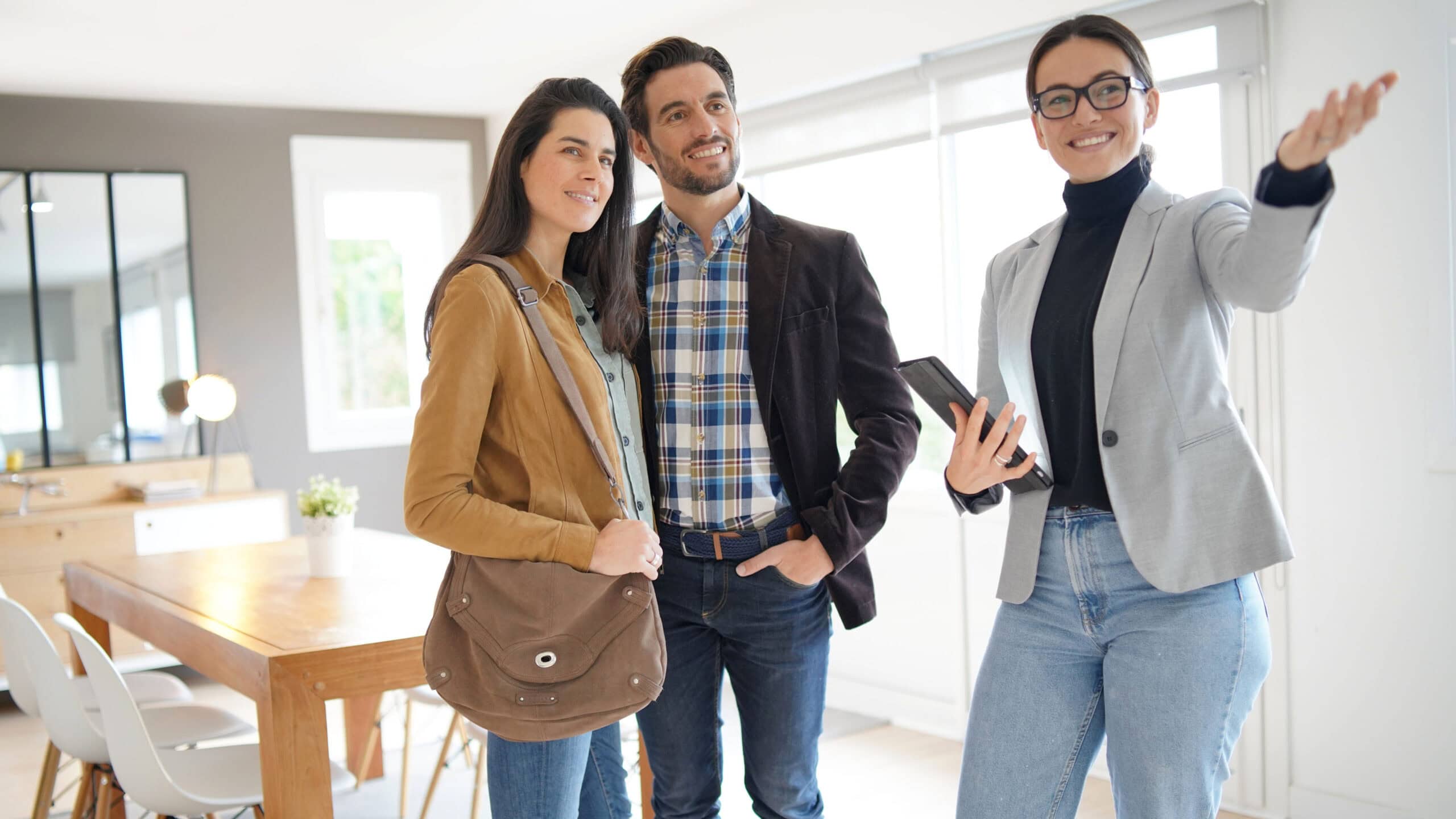 Real estate agent showing modern house to attractive couple