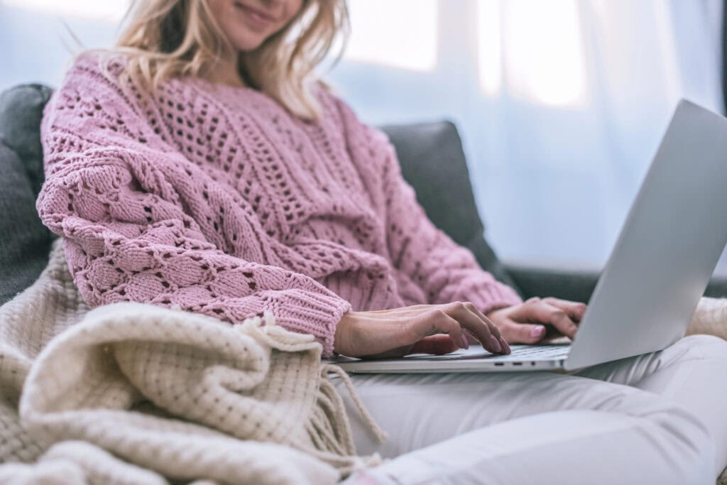Smiling woman using laptop while sitting at home