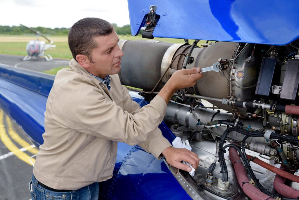 Mechanic fixing the motor of a plane