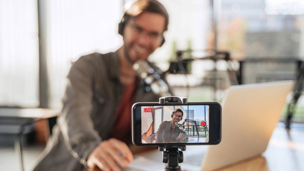 Podcast creator recording video podcast on smartphone