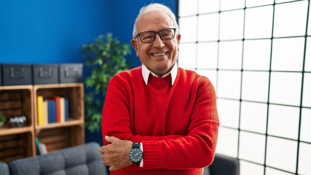 Senior man smiling confident standing with arms crossed gesture at home