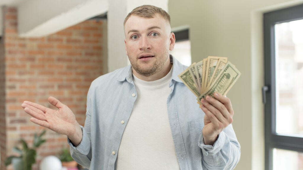 shrugging, feeling confused and uncertain. dollar banknotes concept