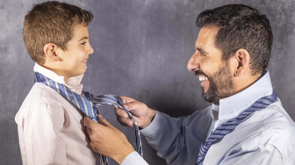 Father teaching a son how to tie a tie