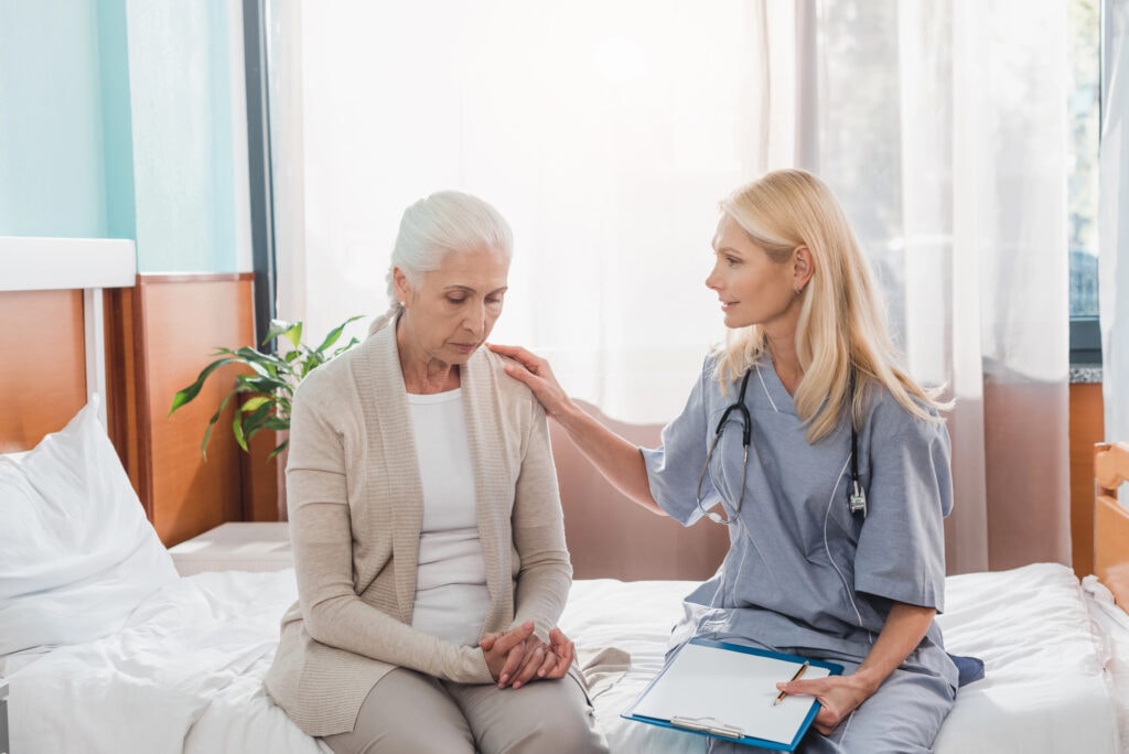 Senior woman and nurse with clipboard