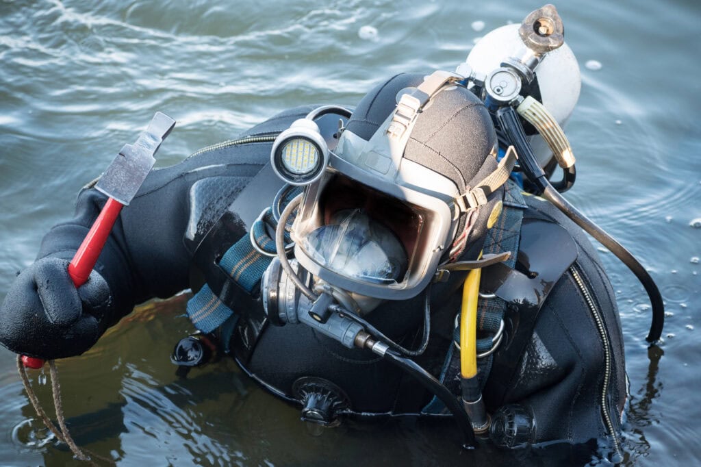 Commercial diver with scuba gear working in the water, occupation in the offshore industry