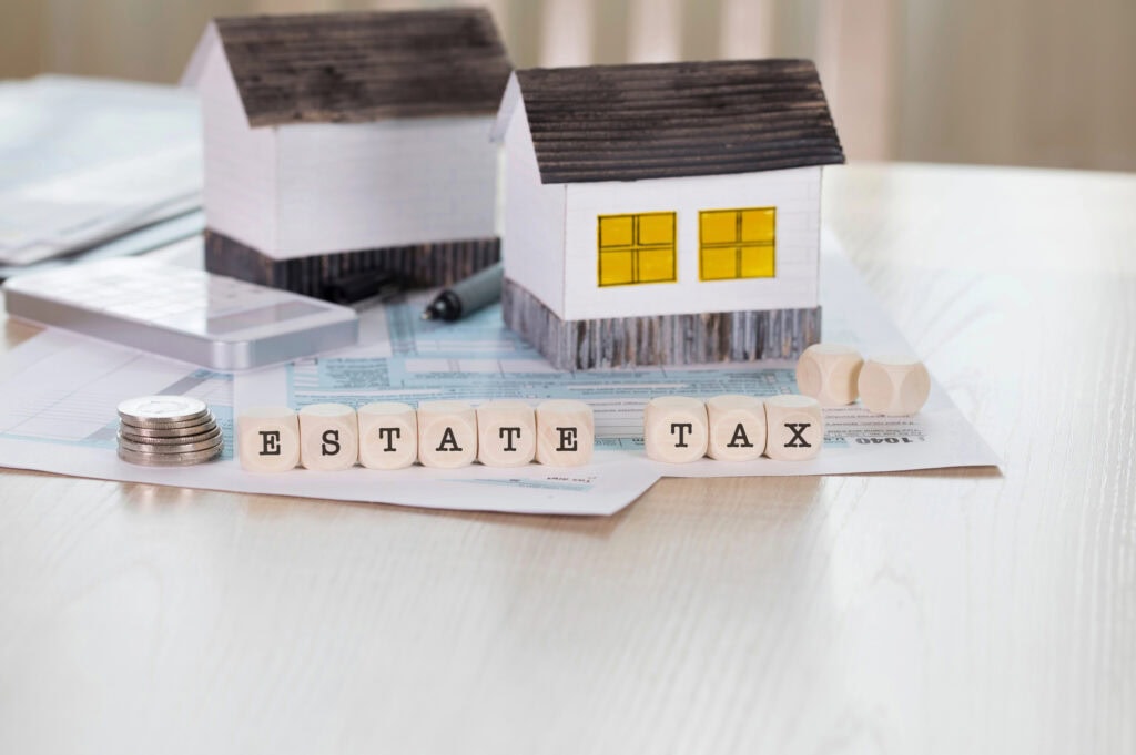 Word ESTATE TAX is composed of wooden letters. Closeup