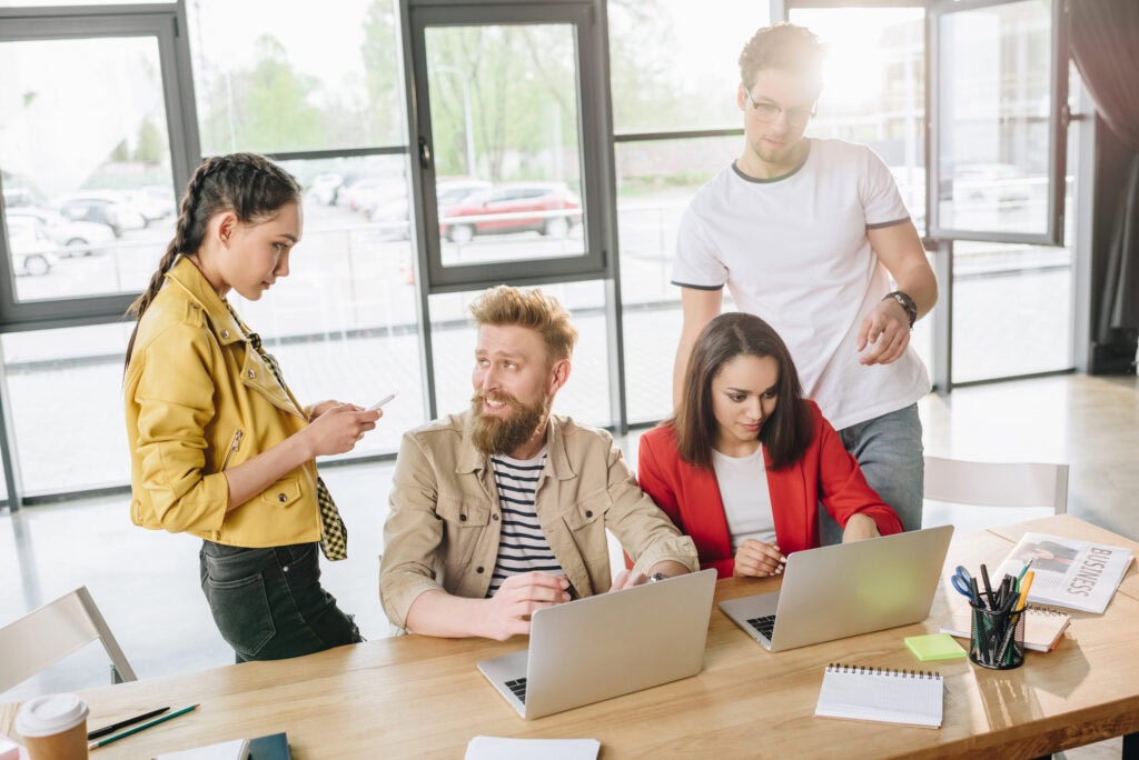 Professional business colleagues men and women discussing ideas in modern office