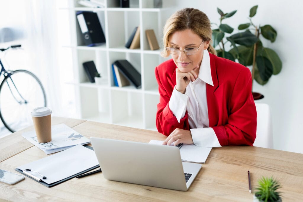 Attractive businesswoman looking at laptop in office