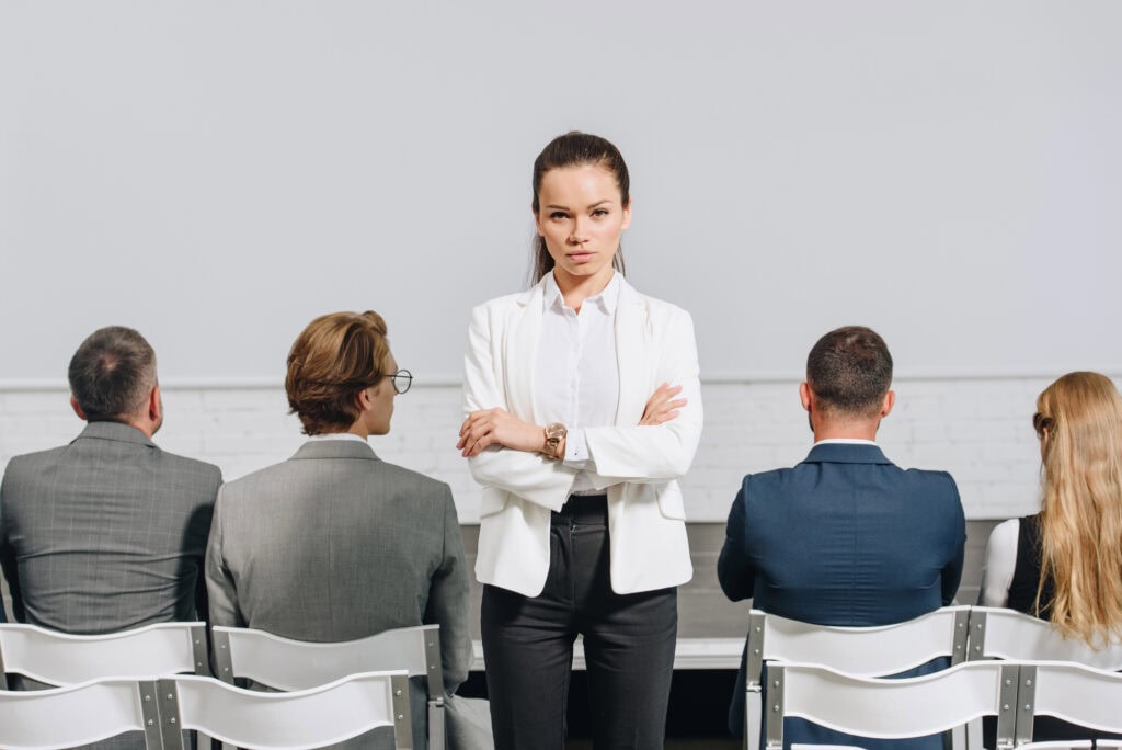 Woman crossed arms looking at camera during business training in hub