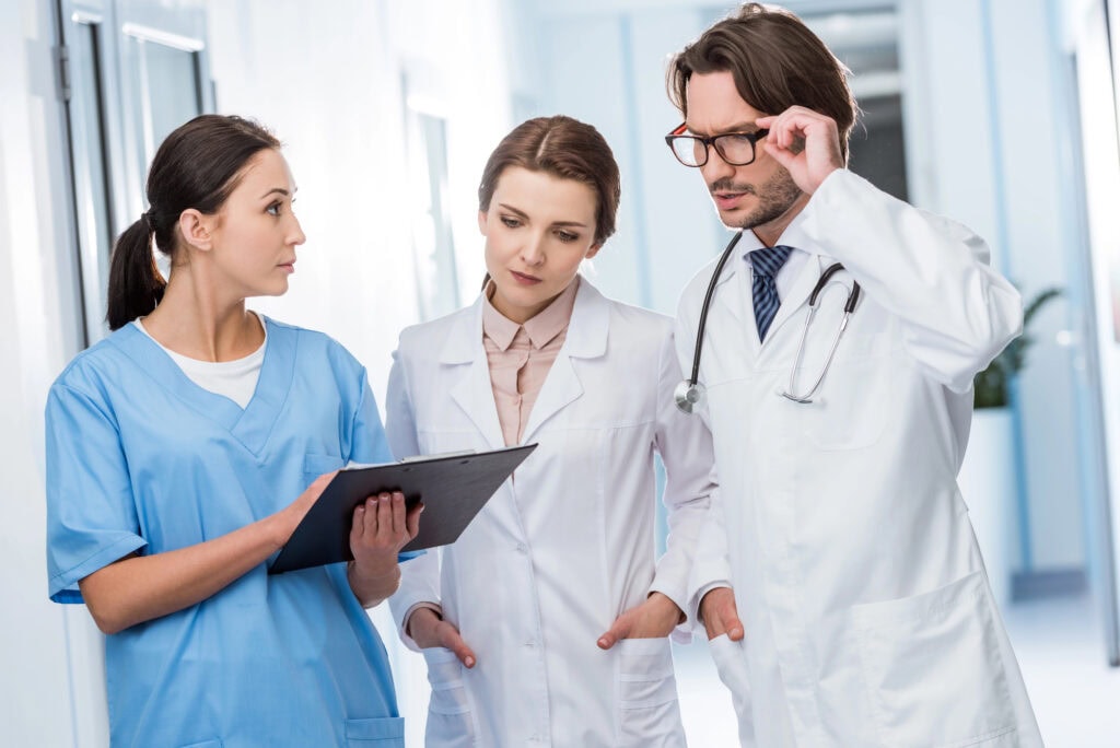 Doctors discussing diagnosis with nurse in clinic