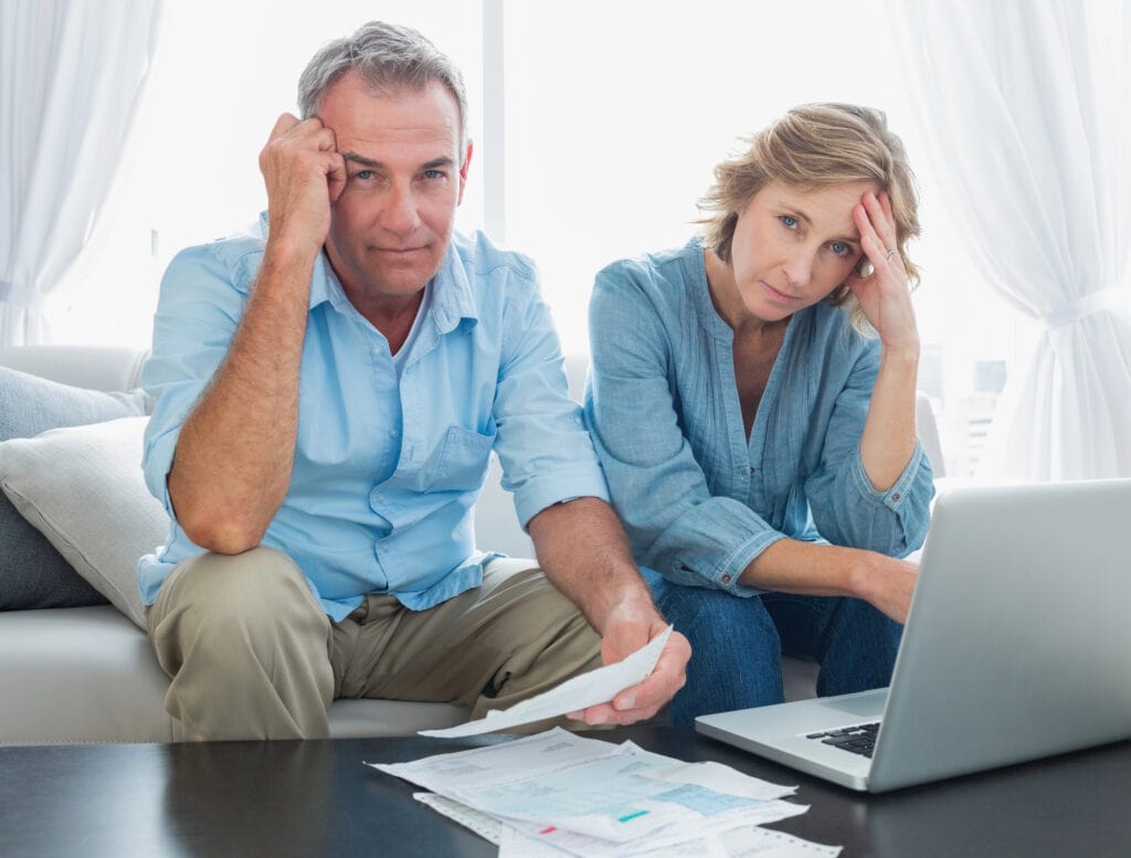 Anxious couple paying their bills online with laptop