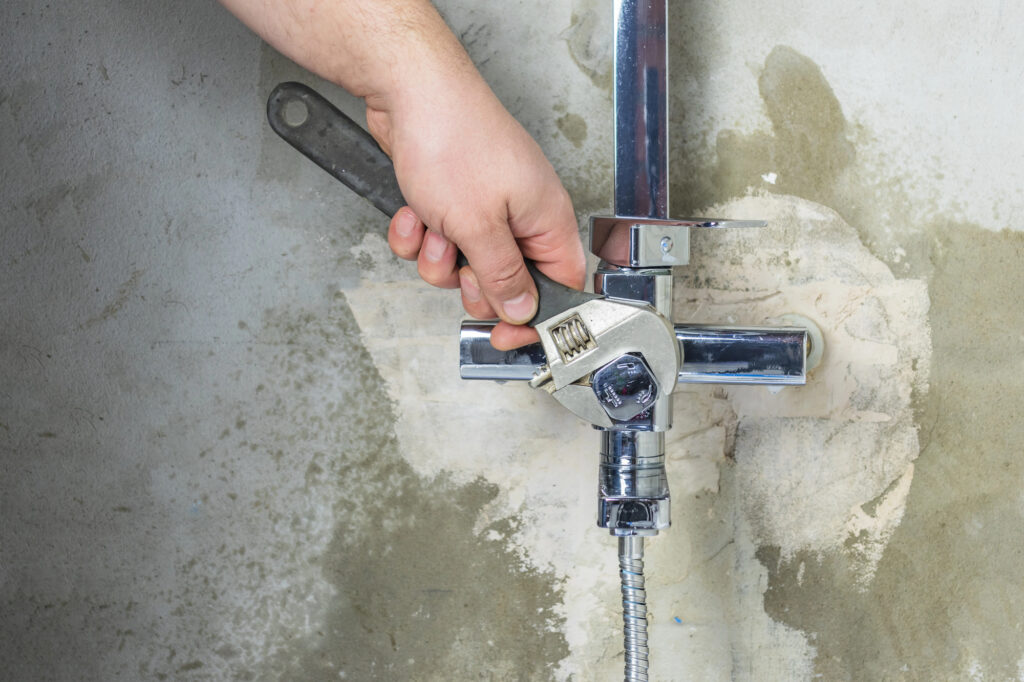 Close-up. the master clamps the nut. fasten the tap to the wall.