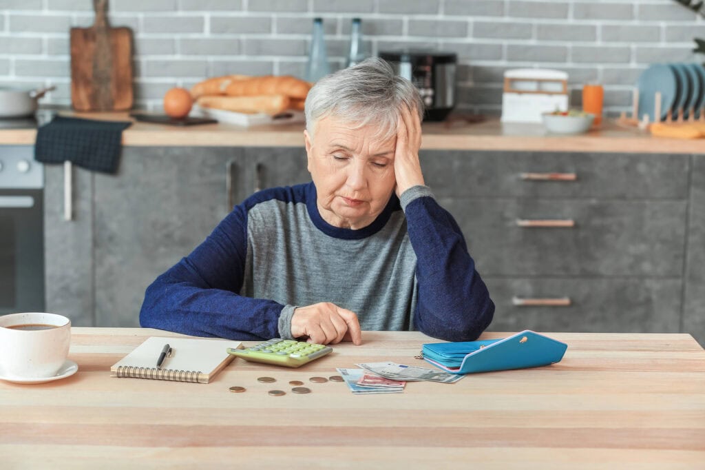 Senior woman counting money at home
