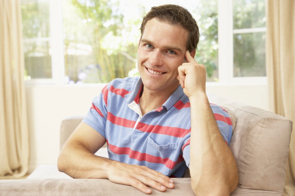 Man Relaxing On Sofa At Home
