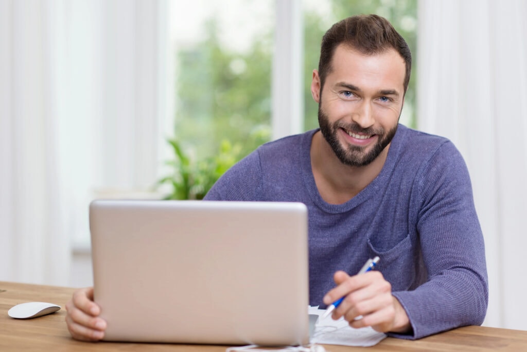 Smiling businessman working on a laptop