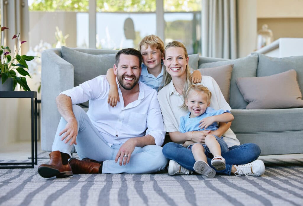 Couple and their kids sitting in the living room at home.