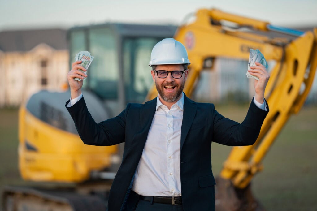 Construction manager in suit and helmet at a construction site. Construction manager worker or supervisor wearing hardhat in front of house
