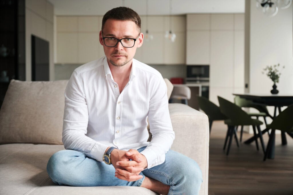 Man sitting on a couch, serious expression