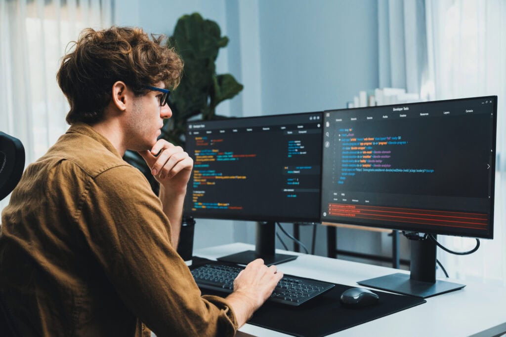 Working IT developer with stressful overworked in creating online software development coding on pc screen.