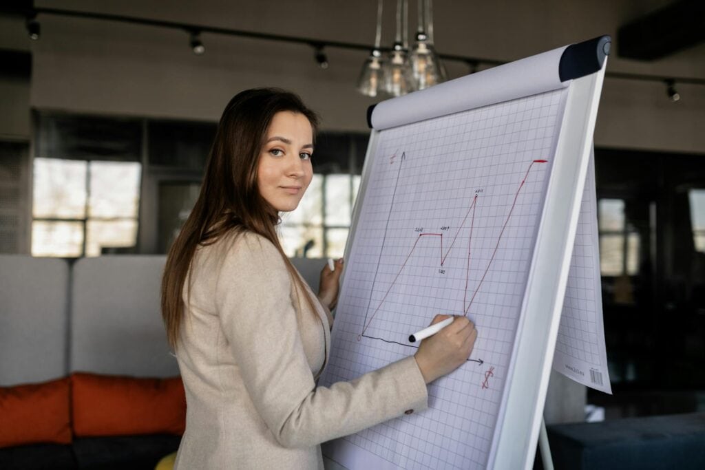 Woman in a Beige Blazer Writing on a Graph