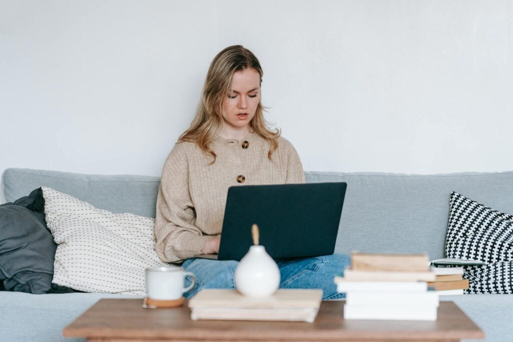 Serious woman freelancing with laptop at home