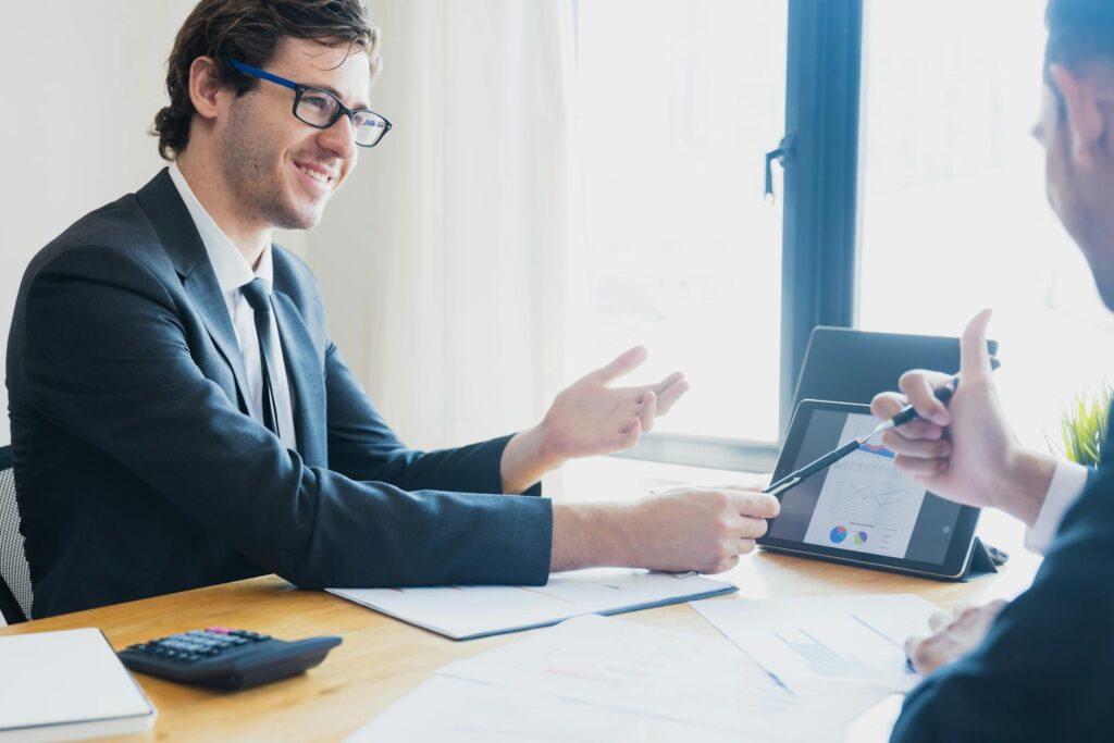 A Man in Black Suit Presenting Using a Tablet Device