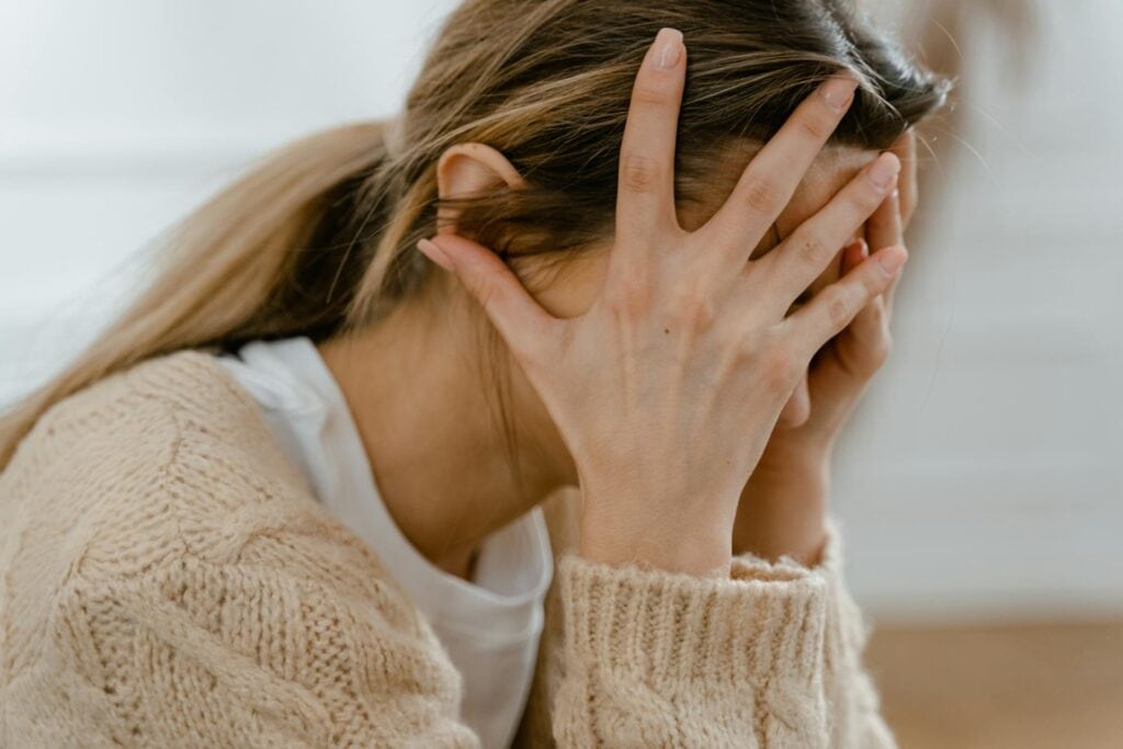 Stressed woman hands covering face. 