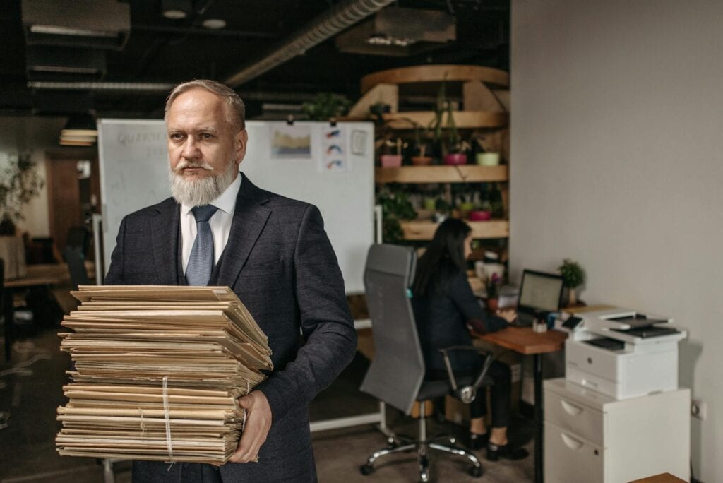 An Elderly Man Carrying Envelopes of Documents