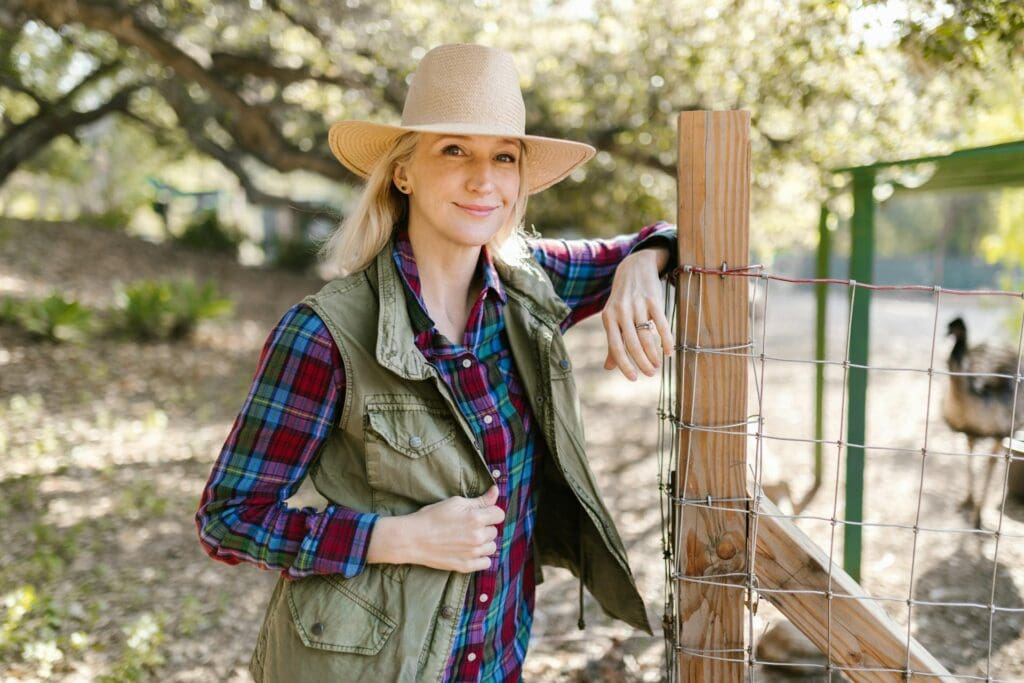 Blonde Woman Wearing Straw Hat Standing Beside the Fence