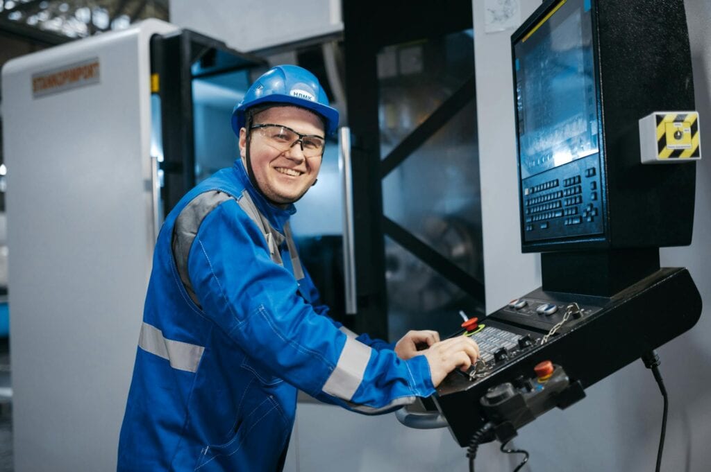 Smiling Industrial Worker Operating CNC Machine