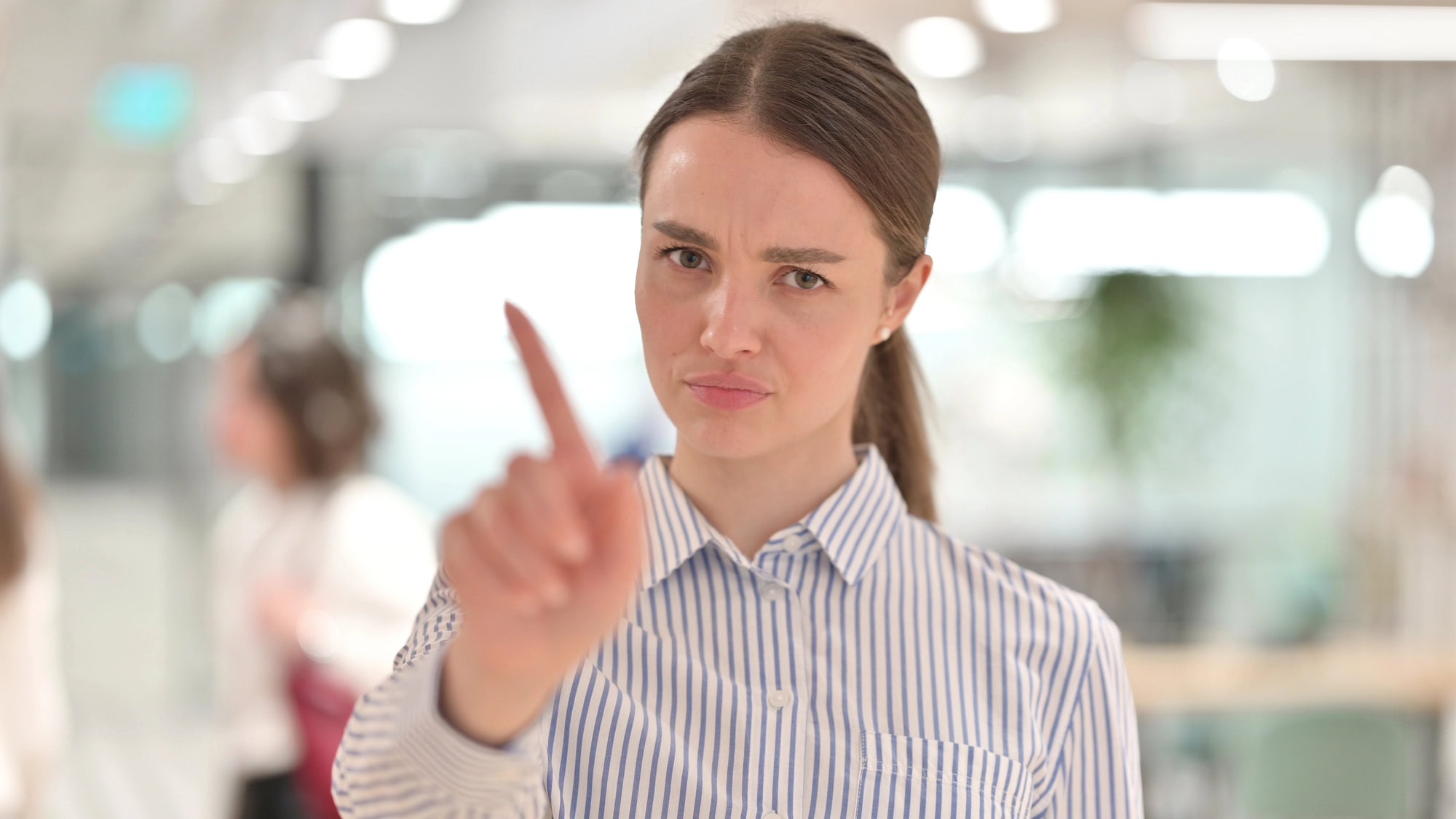Portrait of Disappointed Young Woman saying No by Finger Sign