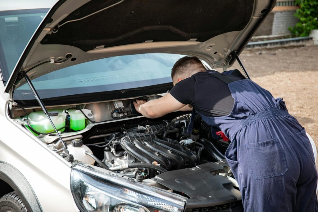 Man in Black Crew Neck T Shirt Fixing a Car