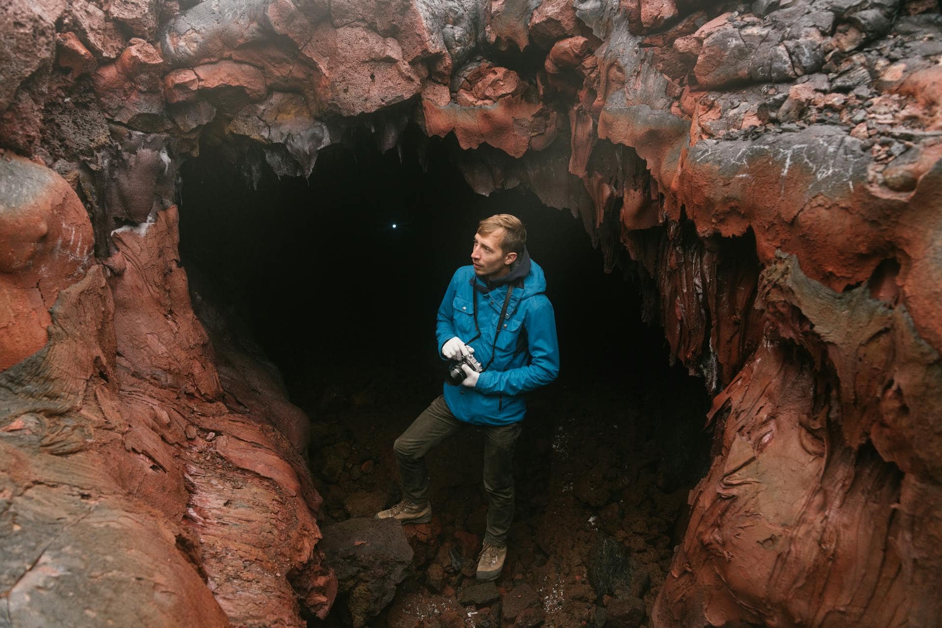 Man Standing in the Entrance to a Stalactite Cave