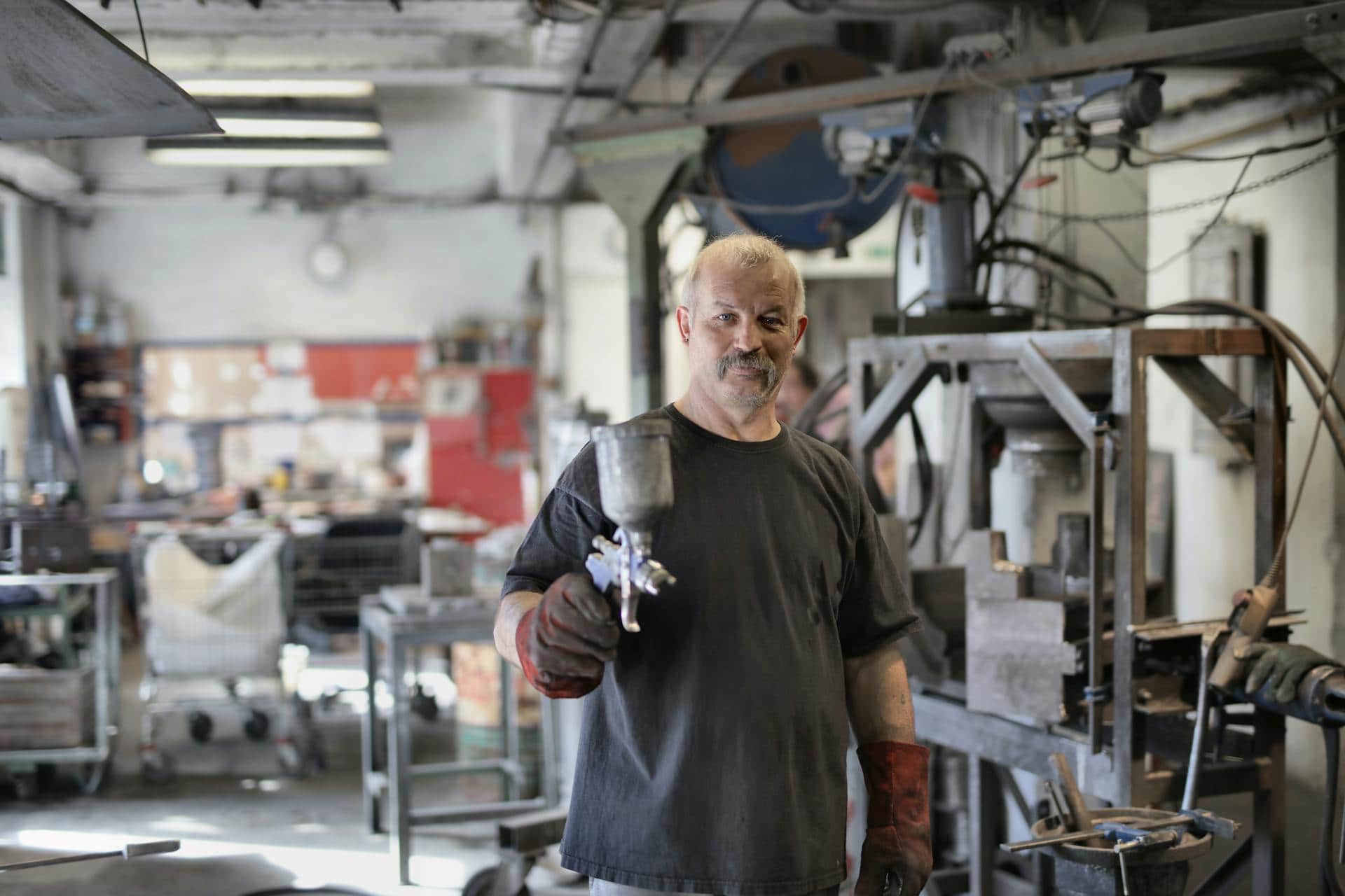 Satisfied elderly worker showing working tool