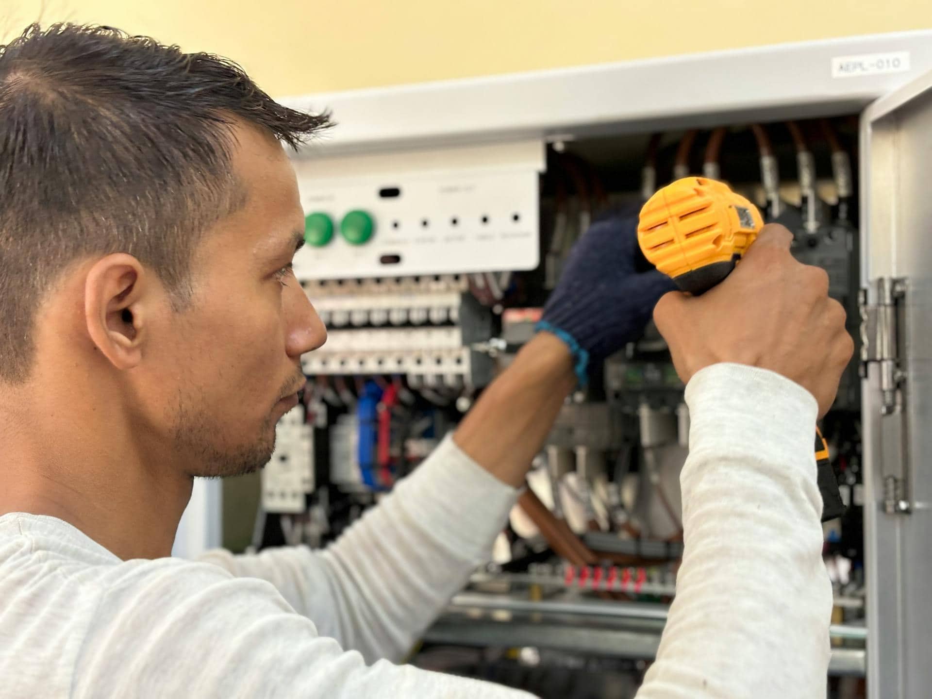 A man is working on an electrical panel