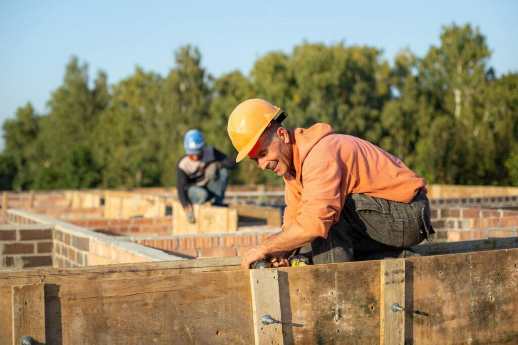 Worker in Protective Helmet at Work on Construction Site